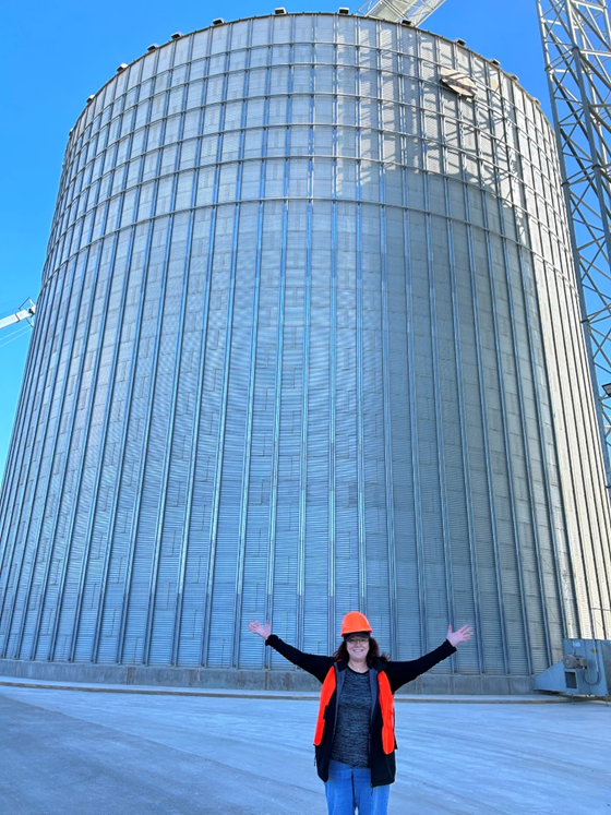 Julie in front a HUGE corn feed silo
